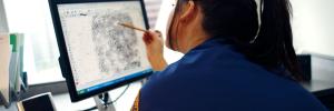 Investigator pointing at a fingerprint on a screen